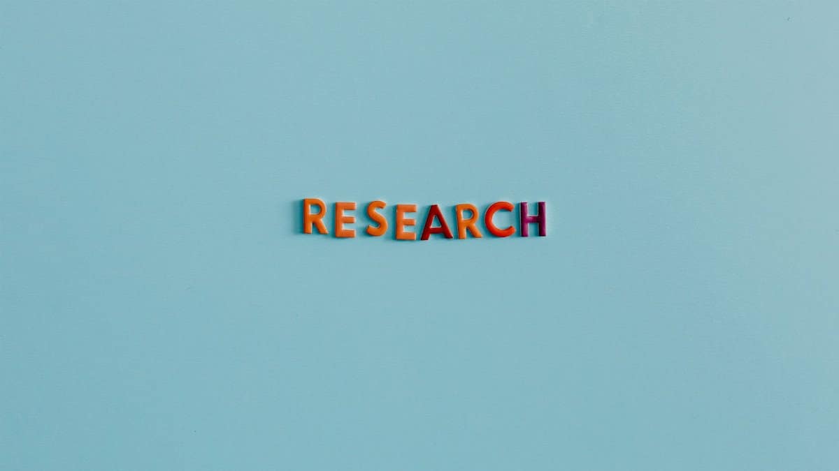 Colorful uppercase letters spelling 'RESEARCH' on a soft blue background. Ideal for education and science topics.