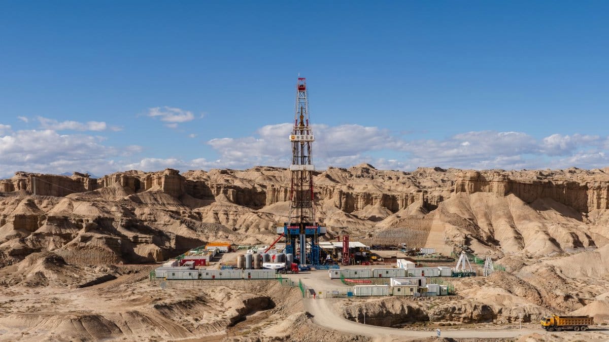 Aerial view of an oil rig amidst desert rock formations, showcasing industrial exploration.
