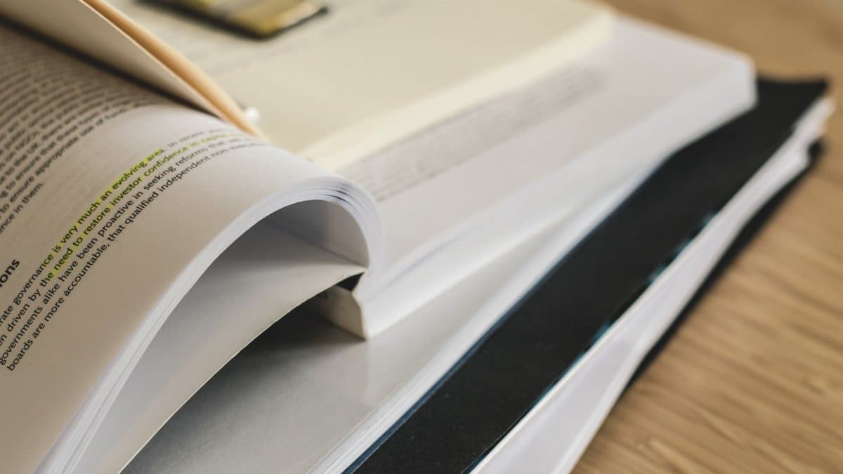 A pile of open books on a table, ideal for study and research themes.