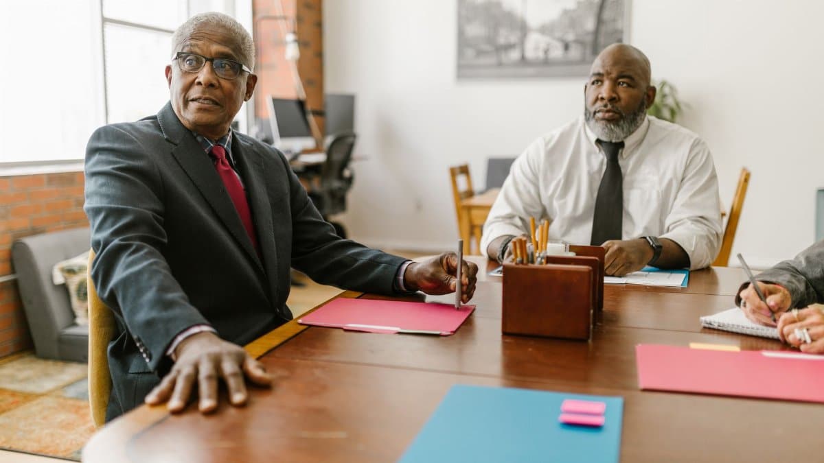 Senior businessmen in a modern office engaged in a collaborative meeting.