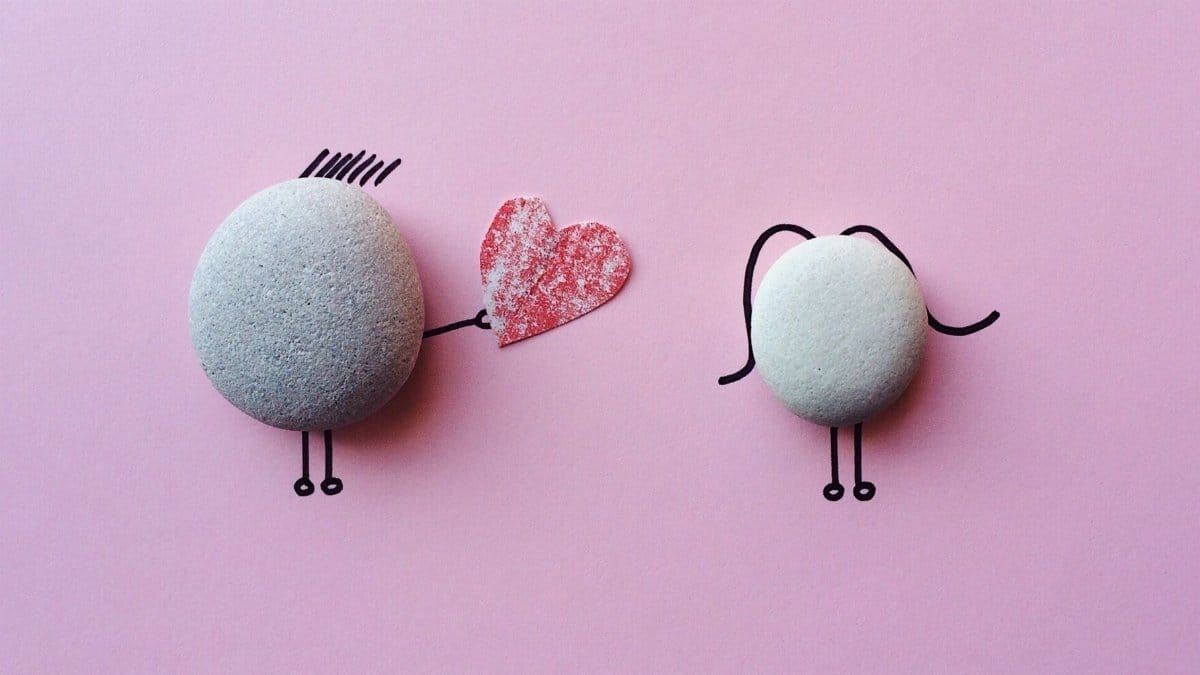 Charming stone art with heart symbol on pink background, symbolizing love and connection.