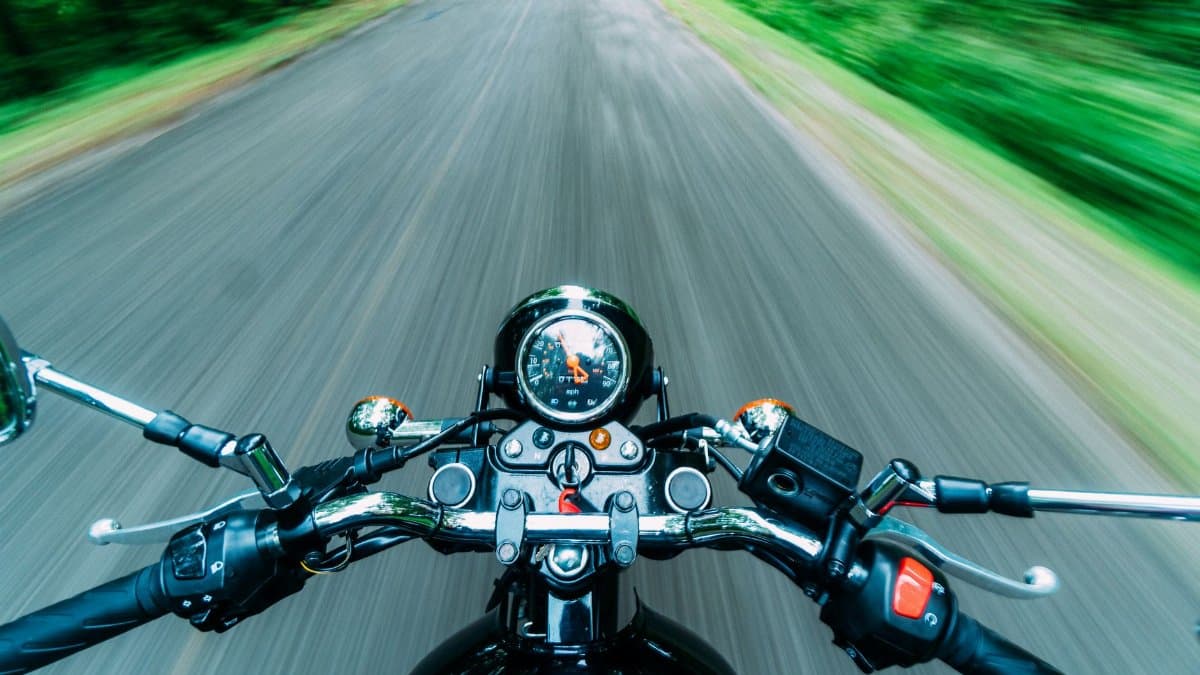 Experience the thrill of a high-speed motorcycle ride through nature's scenic road from a rider's perspective.