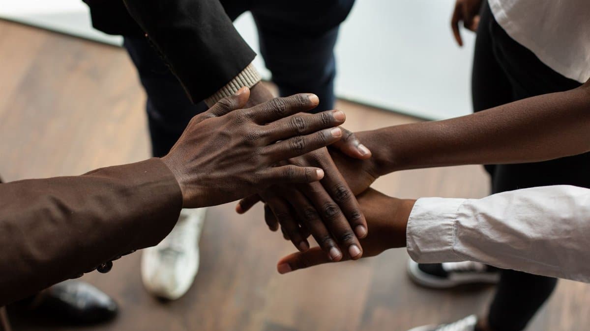 High angle view of diverse hands stacked together, symbolizing teamwork and unity.