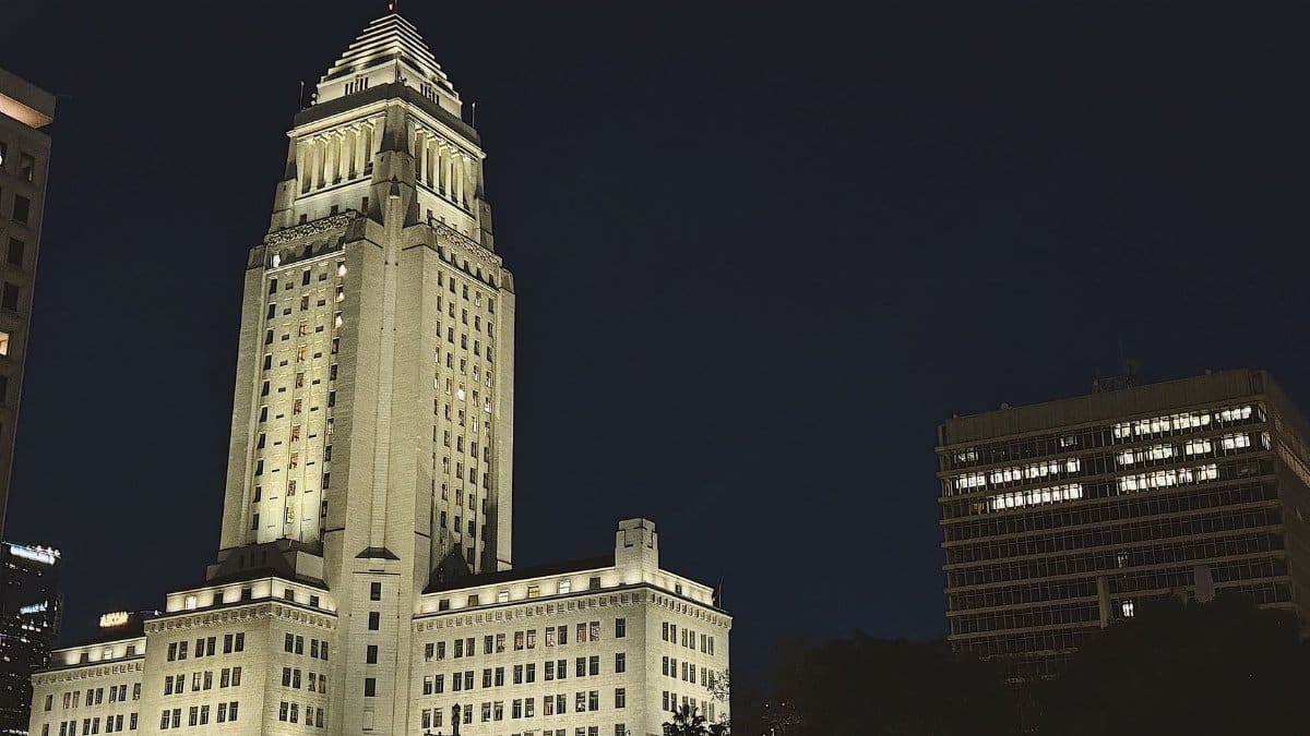 A striking night view of Los Angeles City Hall lit up, showcasing its iconic architecture.