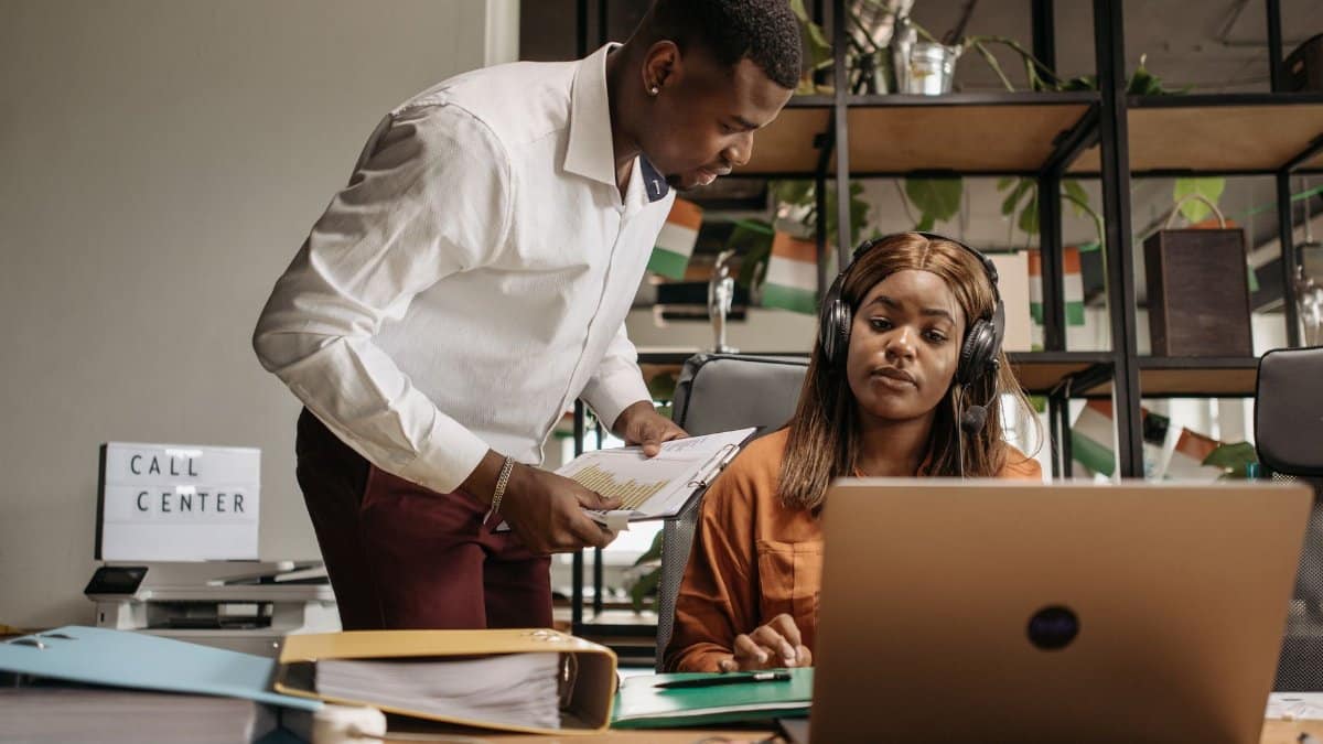 Call center employees collaborating with modern technology, promoting teamwork and efficiency.