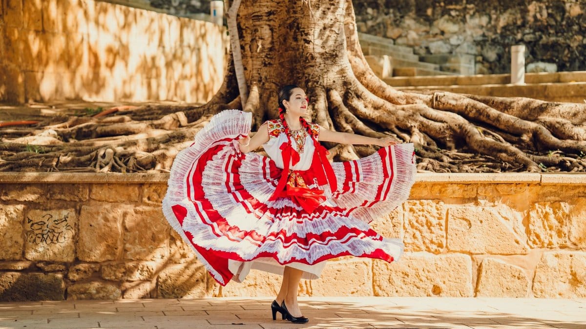Woman dances in vibrant traditional attire in Oaxaca, showcasing Mexican culture and heritage.