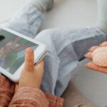 A child watches a cartoon on a tablet as an adult holds a brain model.