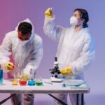 Two scientists in protective gear conducting experiments with colorful chemicals in a lab.