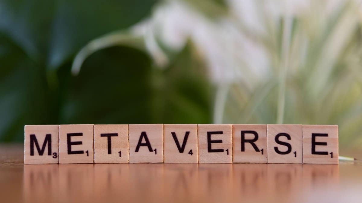 Scrabble letters spelling 'Metaverse' on a wooden surface with a blurred nature background.