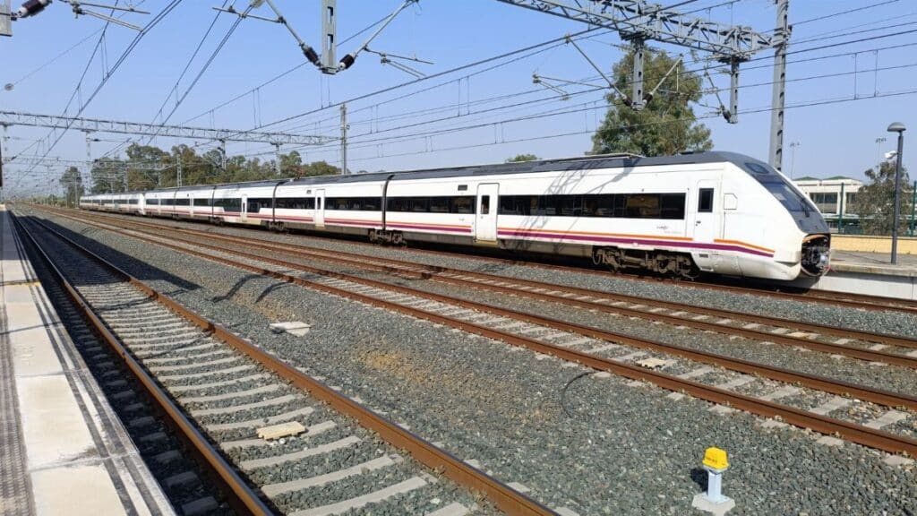 High-speed train at Jerez de la Frontera railway station, sunny day.