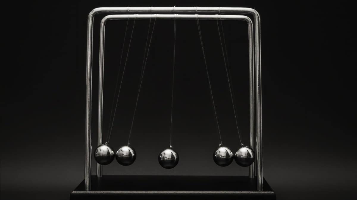 Newton's cradle for physics principles and motion study on a dark background.