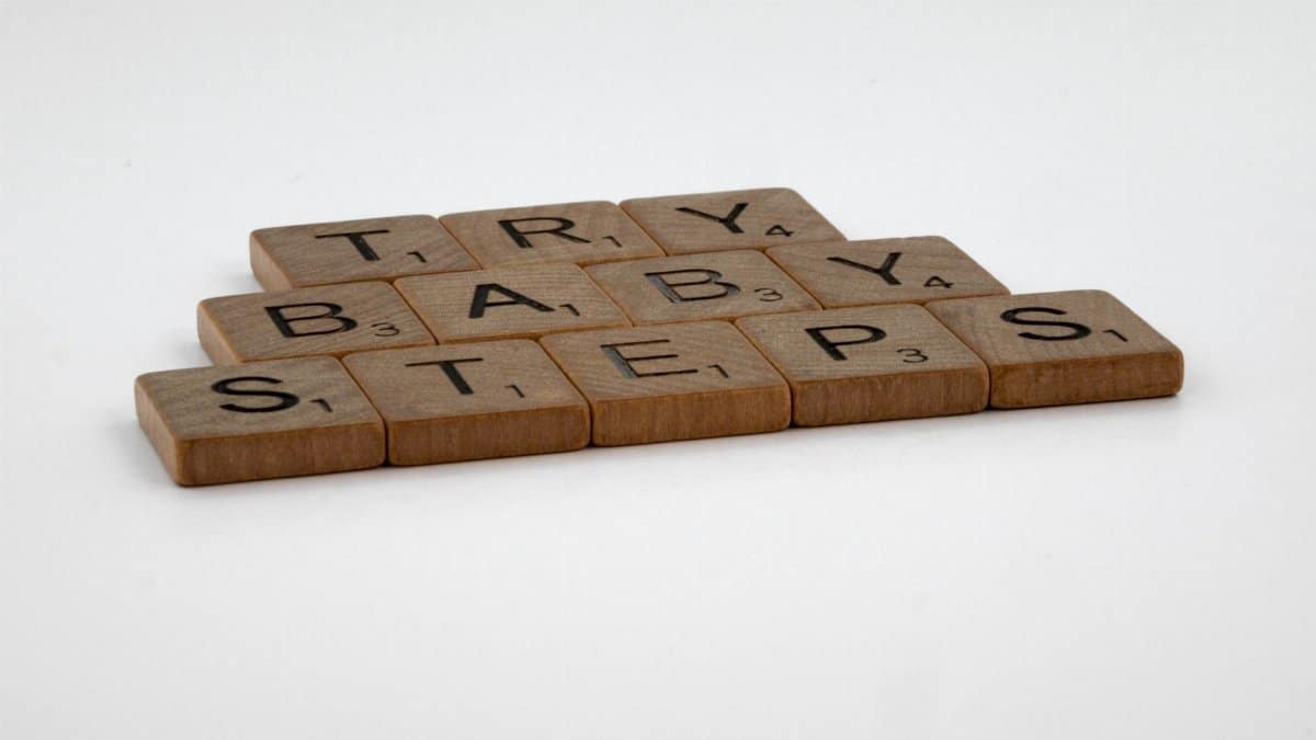 Scrabble tiles forming the phrase 'Try Baby Steps' on a white background.