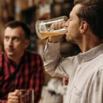 Two men enjoy refreshing draft beer in a cozy pub atmosphere.