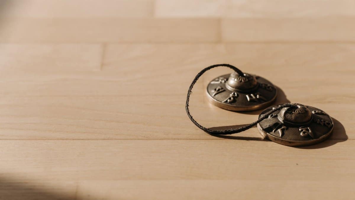 Tibetan tingsha bells resting on a wooden surface, perfect for meditation and spiritual healing content.