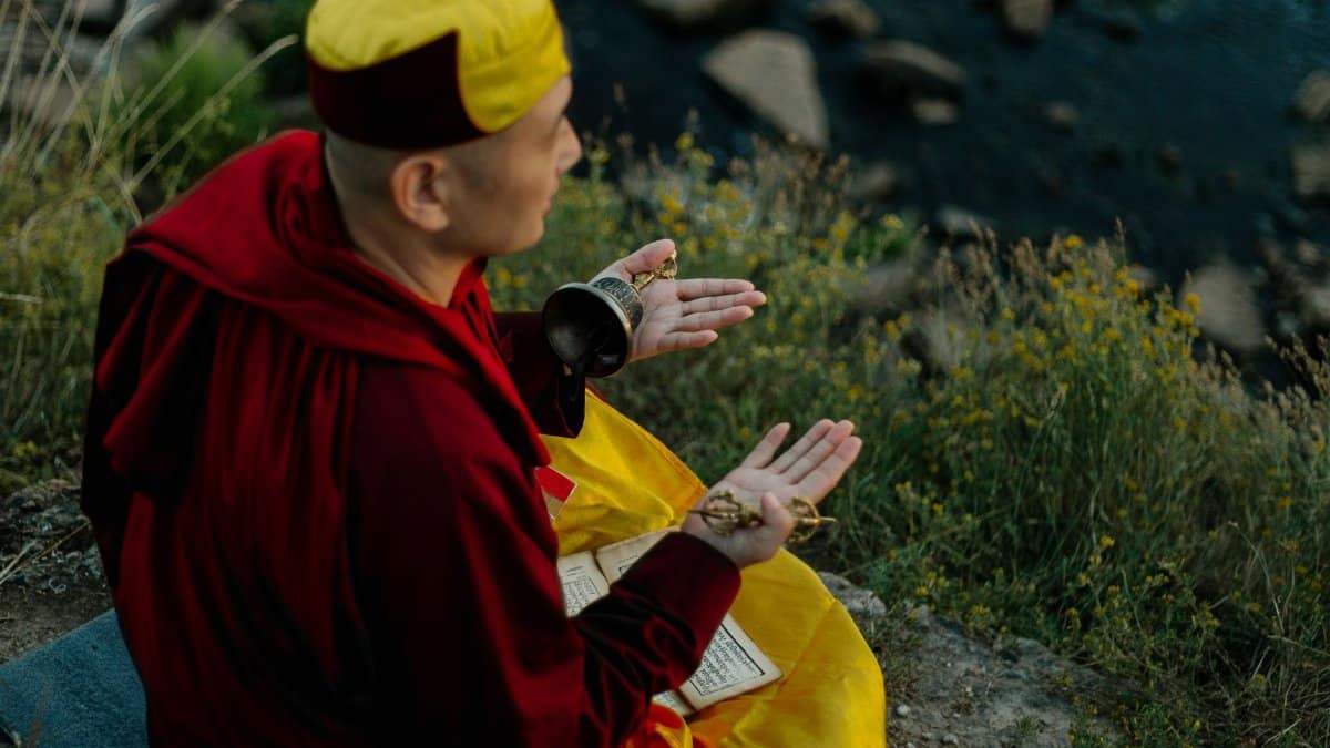 A monk meditating on a riverbank, capturing spiritual tranquility and nature's beauty.