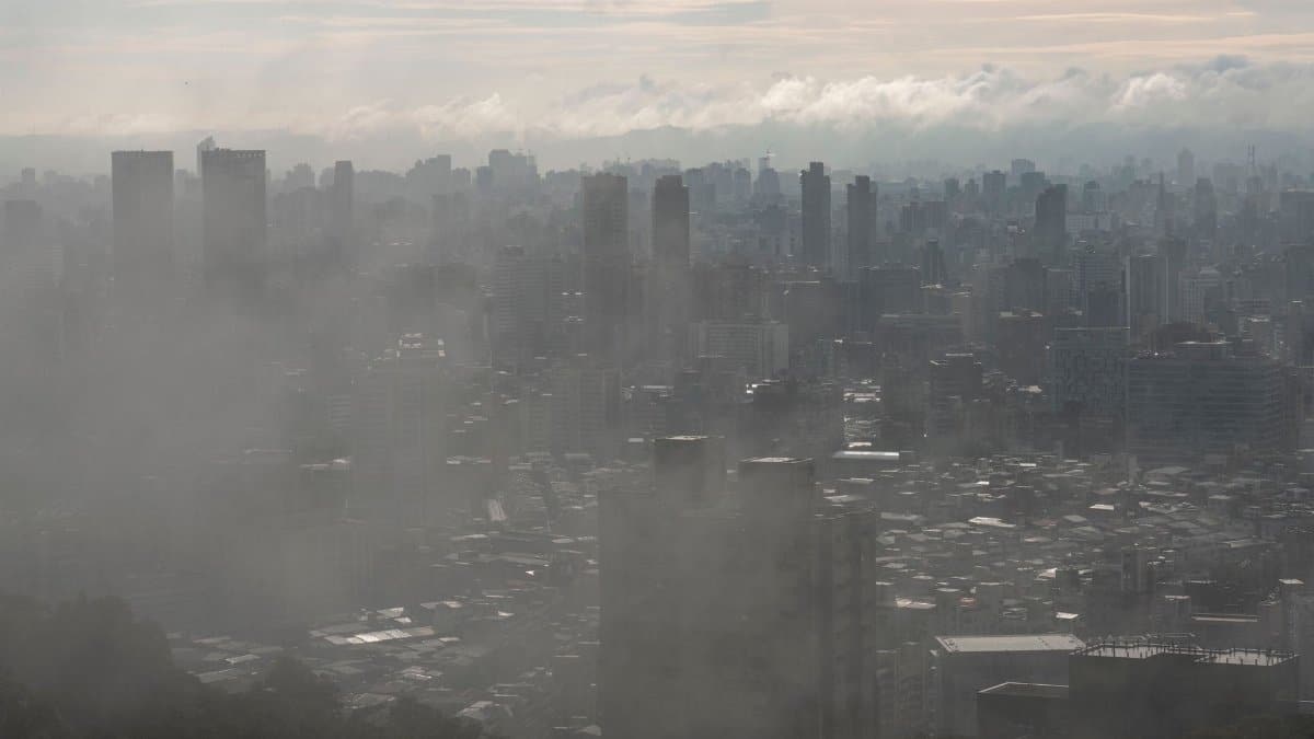 Dramatic view of Taipei's skyline shrouded in fog and atmospheric haze, creating a moody urban scene.