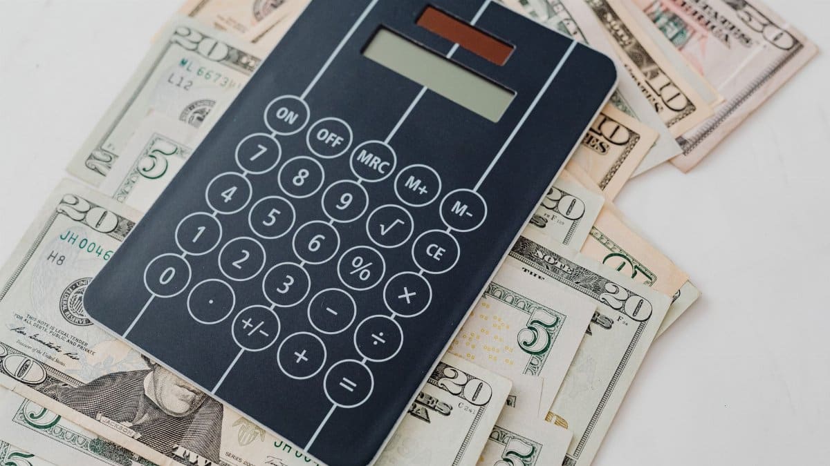 Close-up of a calculator atop US dollar bills, symbolizing financial planning and budgeting.