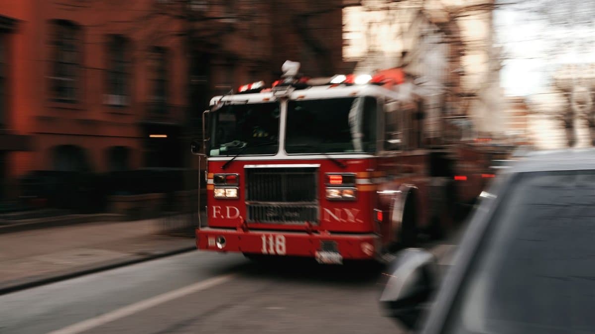 Fire truck speeding through New York City street, capturing the urgency of emergency response.