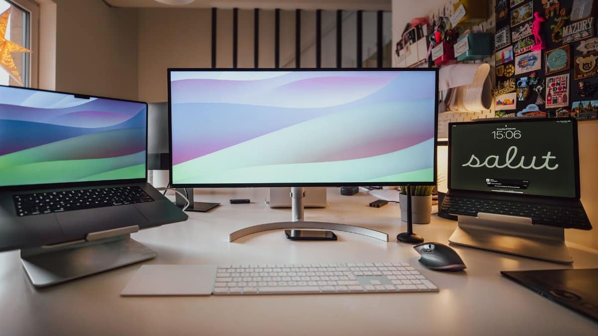 A well-organized home office setup featuring multiple screens and a tidy workspace.