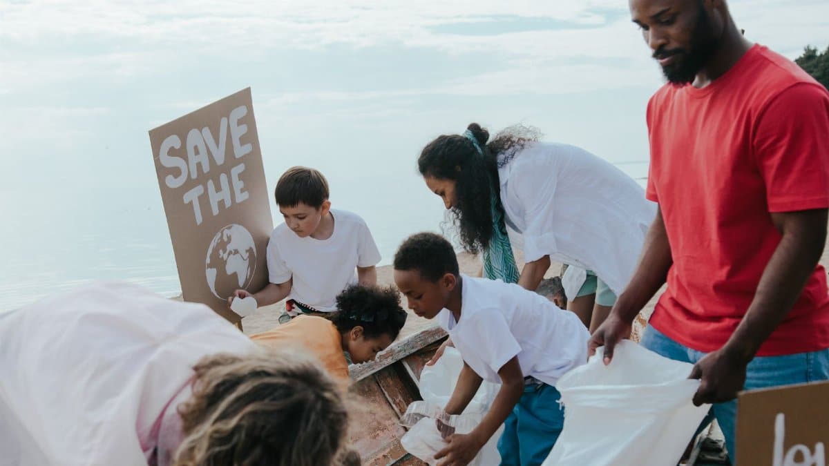 Diverse group of volunteers cleaning up a beach, promoting environmental protection and teamwork.