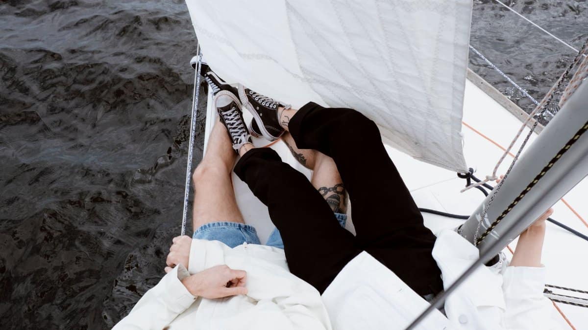 A couple enjoys a leisurely day on a sailboat, embracing the adventure of sailing together.