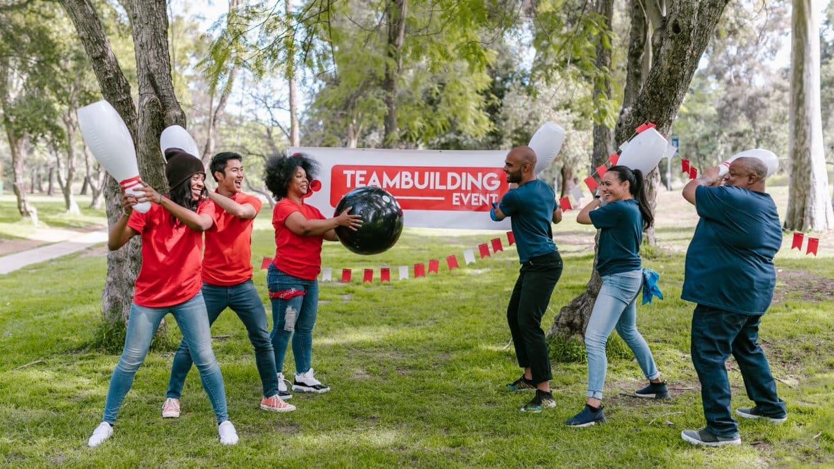 Dynamic outdoor team building activity with diverse group playing in the park.