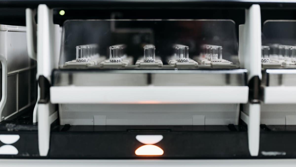 Close-up of laboratory equipment with test tubes in a rack, showcasing modern scientific research tools.