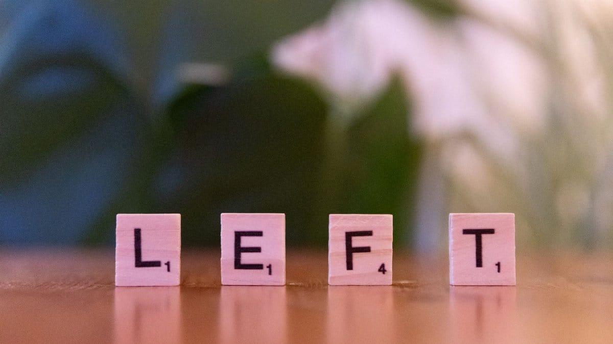 Close-up of wooden Scrabble tiles spelling the word 'LEFT' on a blurred background.