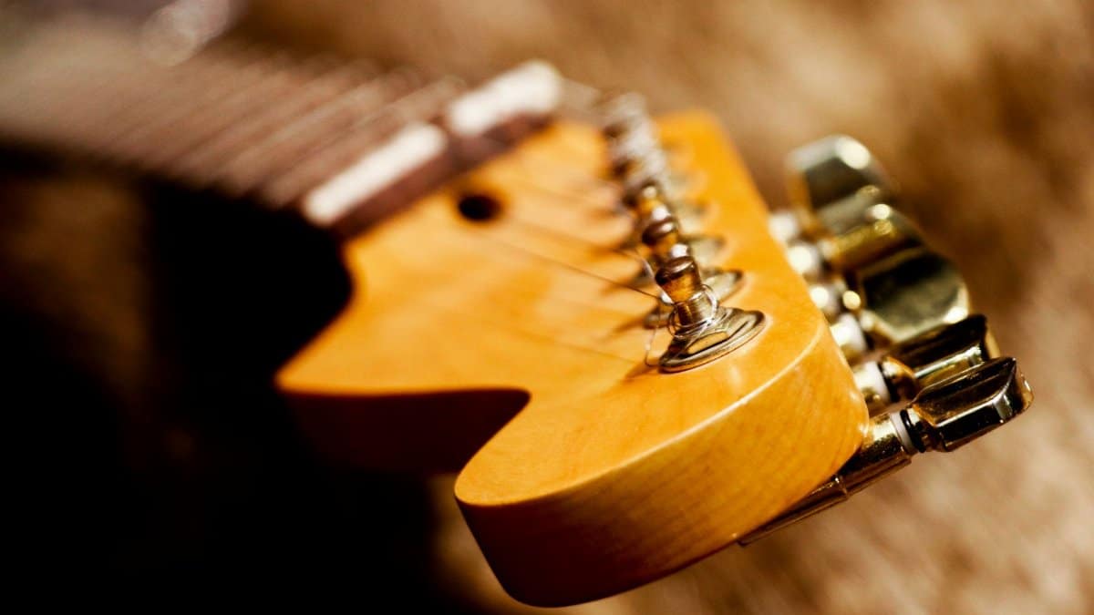 Detailed close-up of an electric guitar's headstock showcasing its strings and tuning pegs.