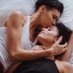 A romantic scene of a same-sex couple embracing in a peaceful, intimate setting at home.