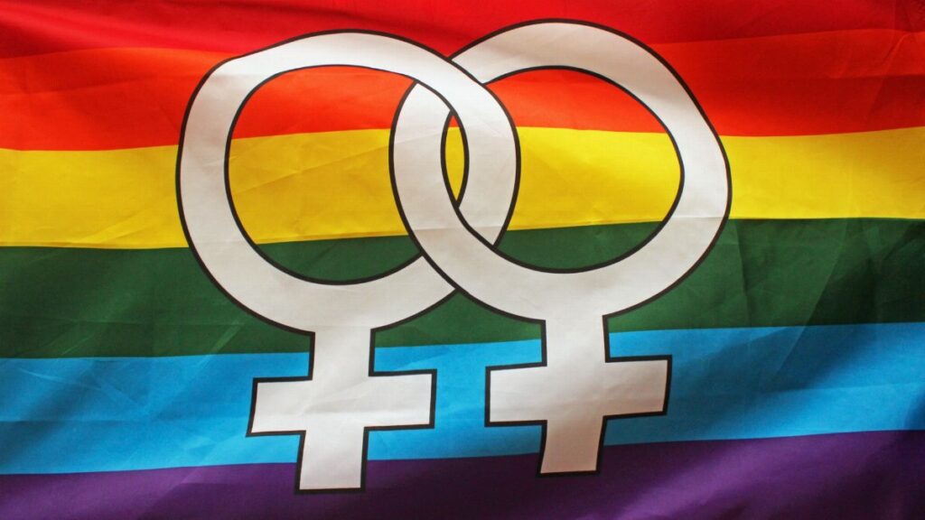 Bright rainbow flag displaying double Venus symbol representing lesbian pride and LGBTQ+ community.