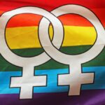 Bright rainbow flag displaying double Venus symbol representing lesbian pride and LGBTQ+ community.