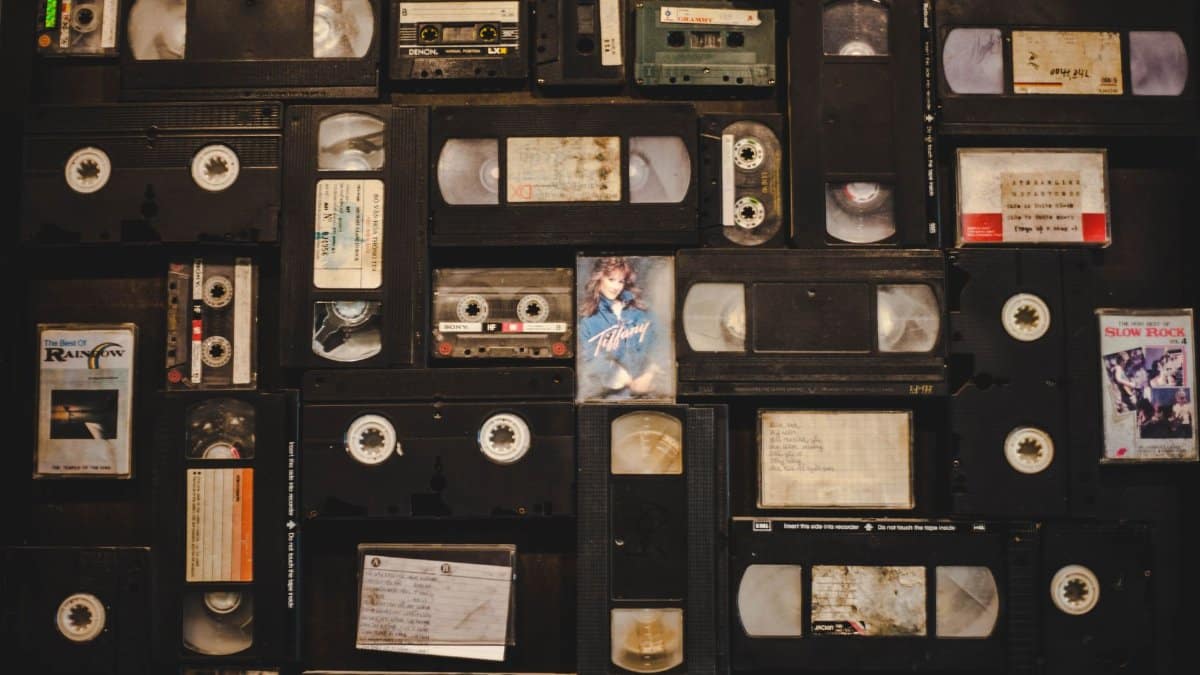 Top view of assorted vintage VHS tapes and cassettes in a nostalgic layout.