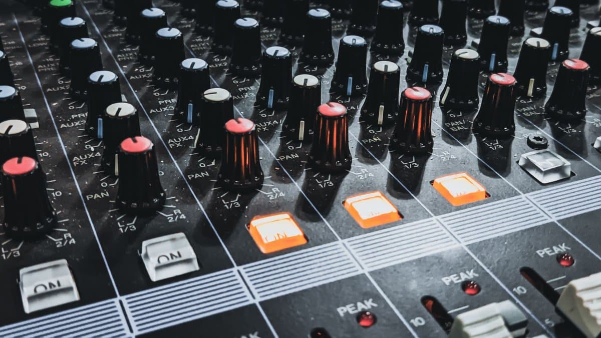 Detailed shot of an audio mixer highlighting knobs and glowing lights, perfect for sound engineering insights.
