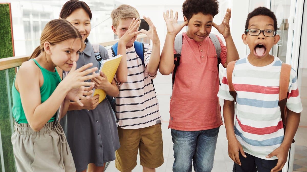 A group of diverse children having fun and making funny faces indoors.