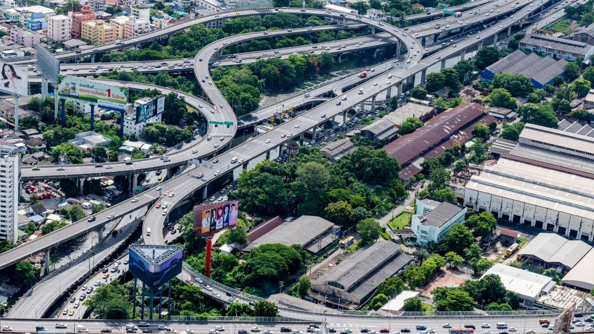 Aerial photo of complex highway interchanges in an urban cityscape.