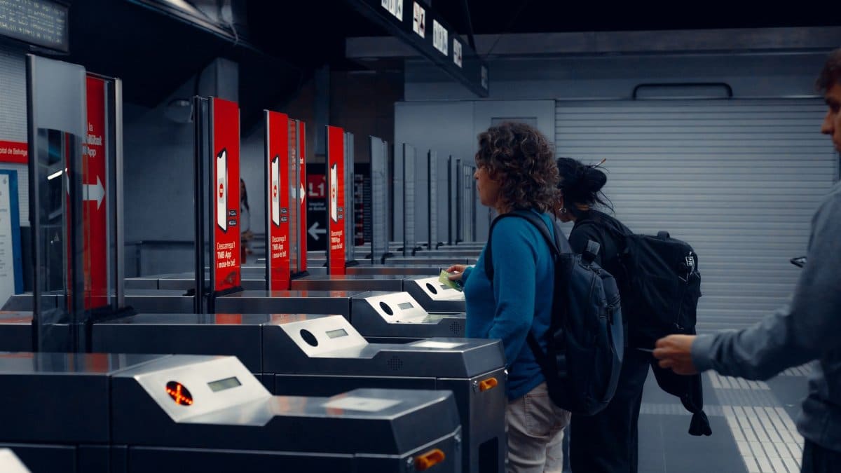 Urban commuters using turnstiles at a modern subway station, showcasing daily public transportation routine.