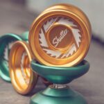 Close-up shot of green and gold yo-yos showcasing detailed design with a blurred background.