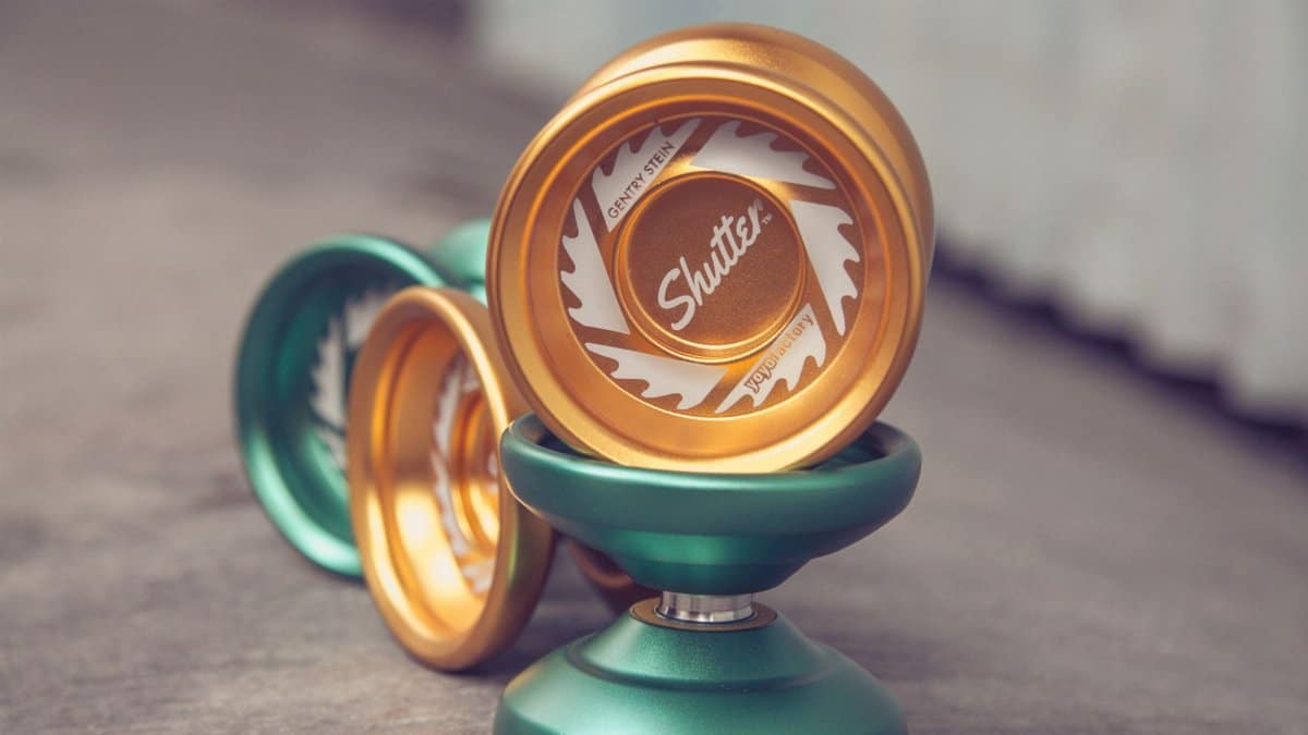 Close-up shot of green and gold yo-yos showcasing detailed design with a blurred background.