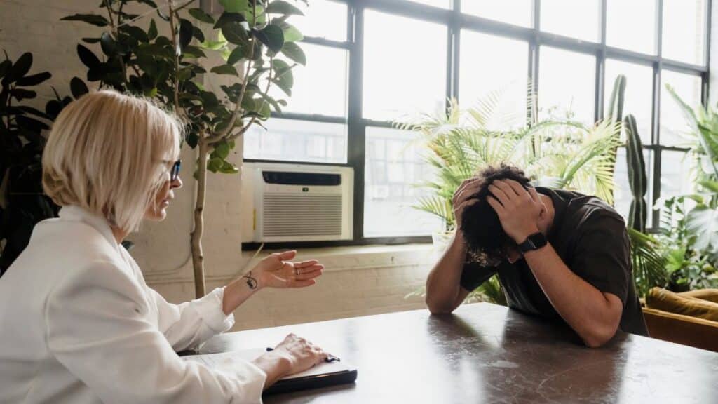 A client expressing distress in a counseling session with a therapist, focusing on mental health support.