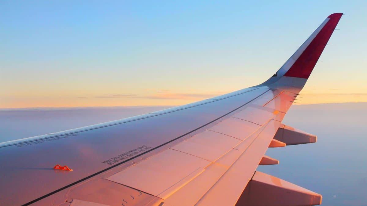 Beautiful view from an airplane wing against a sunset sky, creating a tranquil travel moment.