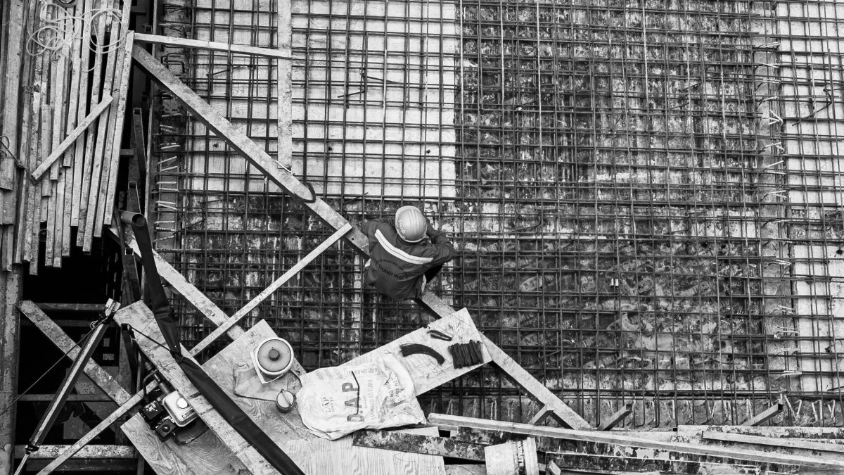 High angle view of a worker at a construction site captured in black and white.