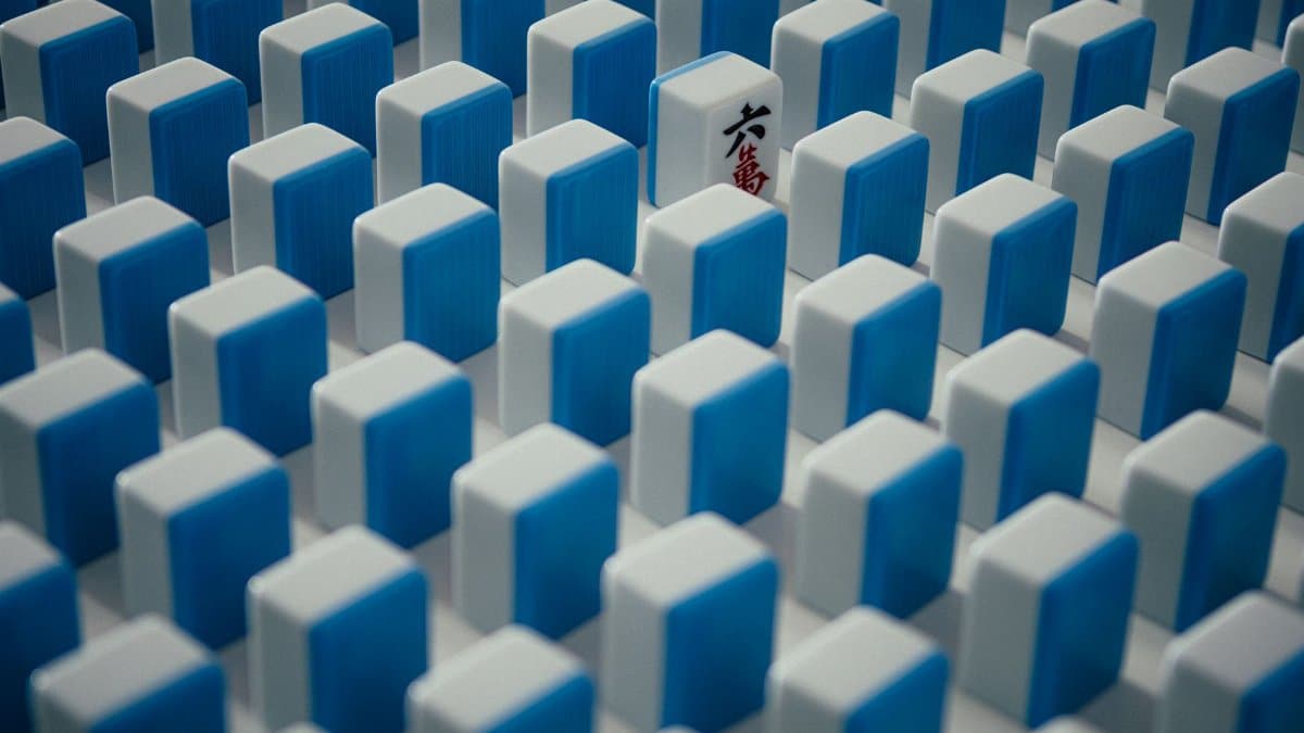 A single distinctive mahjong tile stands out among rows of similar tiles, symbolizing individuality.