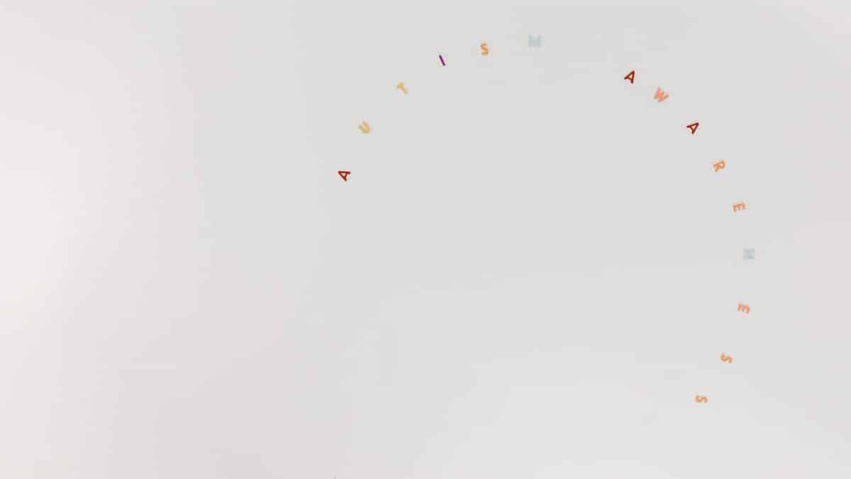 Minimalist design featuring autism awareness lettering on a clean white background.