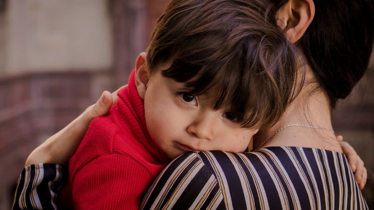 A touching scene of a mother tenderly holding her young son, showcasing love and closeness.