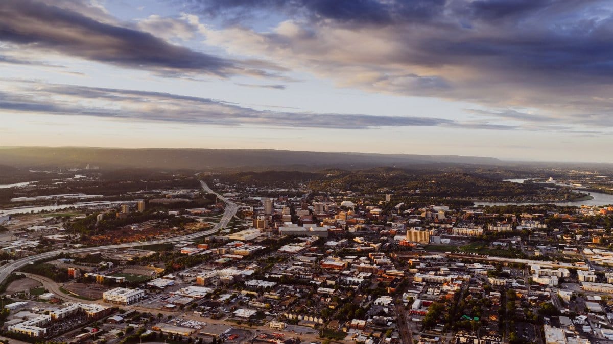 Stunning aerial view of Chattanooga, Tennessee with scenic hills and Tennessee River during sunset.