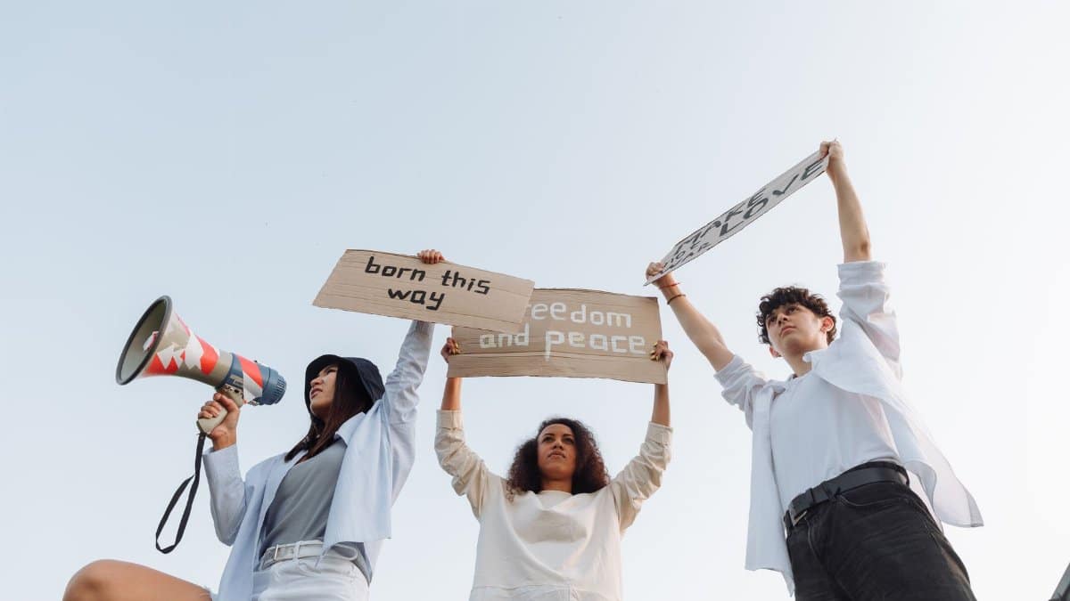 A diverse group of activists holding signs and a megaphone, advocating for freedom and peace.