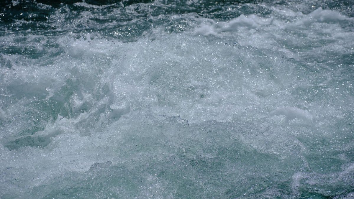 Close-up view of a rushing river with turbulent water showcasing rapid motion and fluidity.