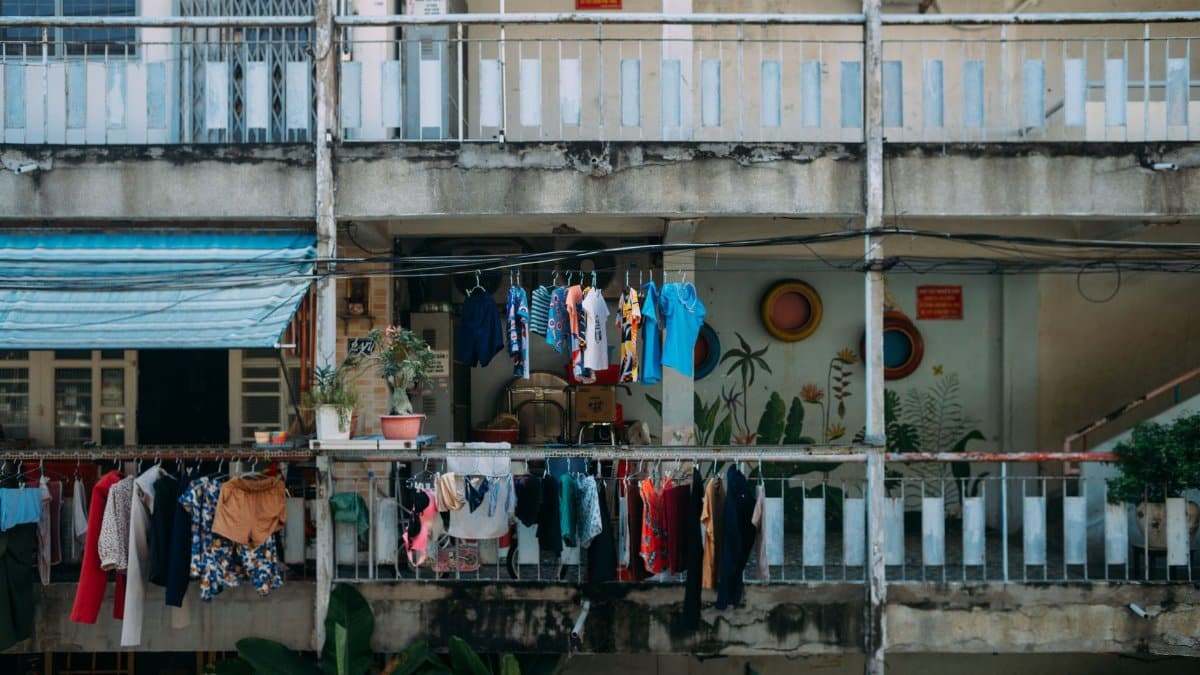 Vibrant clothes drying outside an urban apartment balcony, showcasing daily life.