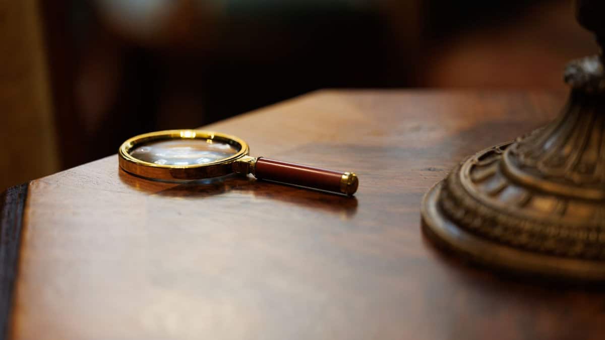 A vintage-style magnifying glass placed on a polished wooden table, exuding an elegant and classic look.